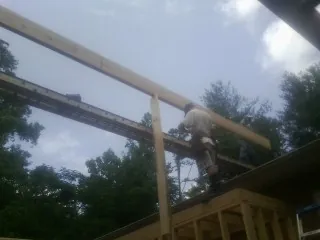 Carpenter setting a ridge beam over a new addition frame — Ice Dam Removal by Roofing Brothers in Marlton