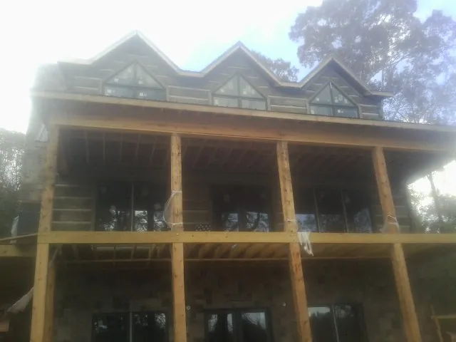 Dormers and porch framing on a large log home under construction — Roof Coating work by our crew in Marlton