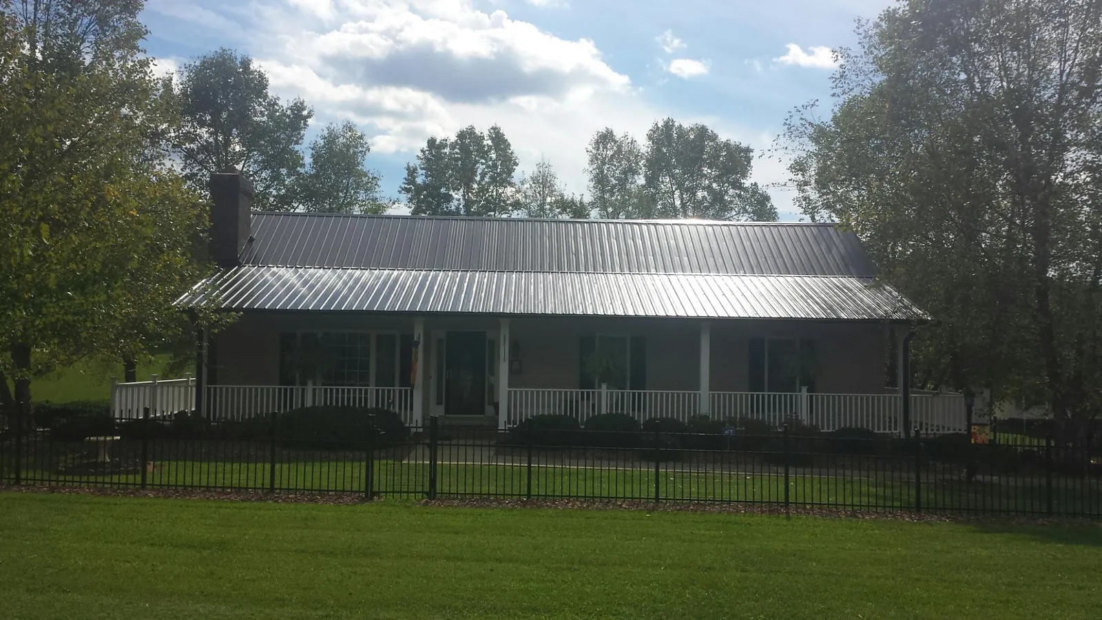 Gray metal roof on a brick ranch with a full width front porch — Gutter Guard Installation work by our crew in Marlton